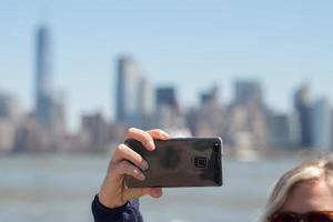 nuovo York Manhattan statua di libertà turista autoscatto con smartphone foto