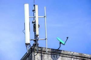 dispositivi e ricevitori segnale di comunicazione con antenne sulla parte superiore dell'edificio e sfondo luminoso del cielo blu. foto