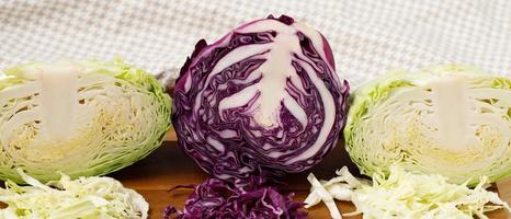 verde e viola cavolo su il di legno taglio tavola nel il cucina foto