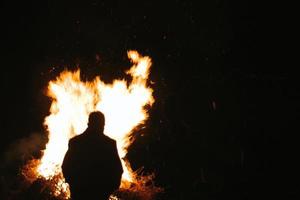 silhouette uomo In piedi nel davanti di fuoco foto