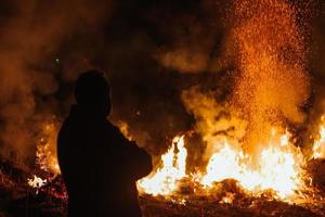 silhouette uomo In piedi nel davanti di fuoco foto