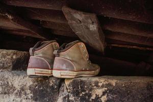 coppie di vecchio tessile figli di verde classico scarpe da ginnastica appendere su un' cordone, blu squallido di legno sfondo foto