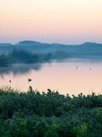 vista di un lago al crepuscolo foto