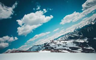 un angolare tiro di snow-capped montagne sotto soffice nuvole foto