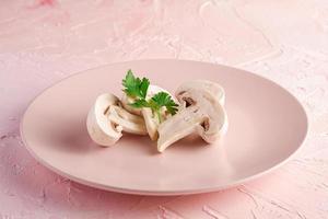 funghi champignon sul piatto rosa foto