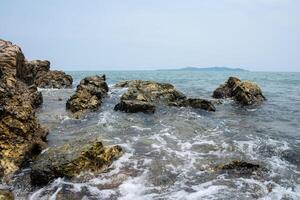 le onde si infrangono sulle rocce foto