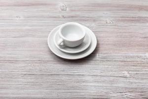 uno bianca tazza con piattini su grigio Marrone tavola foto