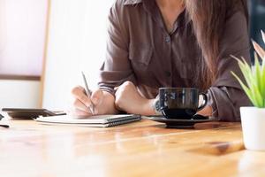 professionista di affari che prende appunti allo scrittorio foto