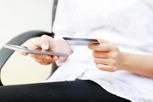 una donna seduta su una panchina usa il suo telefono per pagare lo shopping personale foto