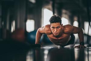 atleta maschio facendo push up in palestra foto