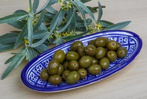 verde olive nel un' ciotola su di legno sfondo foto