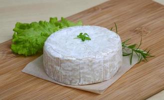 Camembert formaggio su di legno tavola e di legno sfondo foto