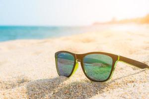 occhiali da sole sulla spiaggia foto