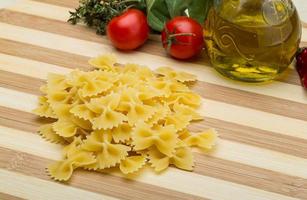 crudo farfalle su di legno tavola e di legno sfondo foto