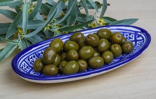 verde olive nel un' ciotola su di legno sfondo foto