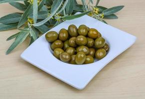 verde olive nel un' ciotola su di legno sfondo foto