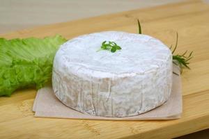 Camembert formaggio su di legno tavola e di legno sfondo foto