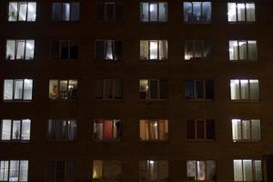 finestre nel Casa a notte. leggero a partire dal finestre di appartamenti. edificio è nel scuro. notte città. foto