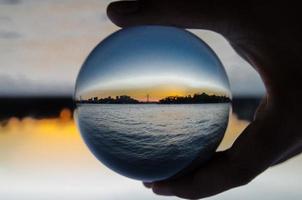 silhouette di paesaggio urbano con oceano Visualizza fotografia bicchiere sfera. foto