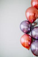 palloncini rossi e viola su superficie bianca foto