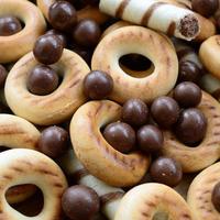 un' lotto di croccante dolce tubuli, cioccolato fusione palle e giallo bagel menzogna su un' di legno superficie. vicino su Visualizza foto