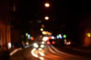 sfocato notte scena di traffico su il carreggiata. sfocato Immagine di macchine in viaggio con luminoso fari. bokeh arte foto