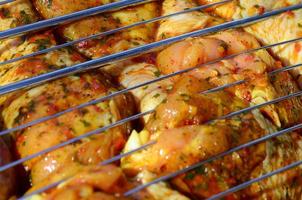 marinato pollo gambe su caldo bbq carbone campo griglia foto