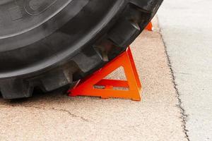 rosso bloccare, cuneo, sotto il ruota di un' estrazione camion. freno scarpa, enfasi. sicurezza ingegneria. foto