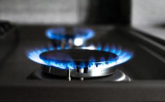 avvicinamento di un' blu fuoco a partire dal un' cucina fornello. Due gas bruciatori con un' ardente fiamma. economia concetto foto