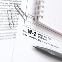 il penna e taccuino su il imposta modulo w-2 salario e imposta dichiarazione. il tempo per pagare le tasse foto