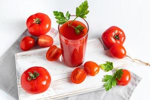 rinfrescante pomodoro succo con erbe aromatiche su bianca sfondo. vegano verdura bere. foto