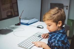 piccolo ragazzo apprendimento per uso computer a casa. foto