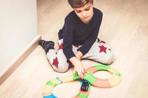 piccolo ragazzo giocando con auto giocattolo su il pavimento. foto