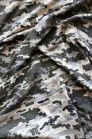 tessuto con struttura di ucraino militare pixeled camuffare. stoffa con Camo modello nel grigio, Marrone e verde pixel forme. ufficiale uniforme di ucraino soldati foto