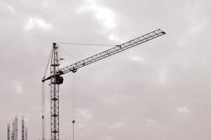 astratto industriale sfondo con costruzione Torre gru al di sopra di chiaro blu cielo. costruzione luogo. edificio sotto costruzione concetto. retrò tono foto