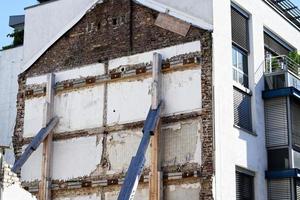 supporto di un' edificio parete con di legno puntoni dopo demolizione di un vecchio edificio foto