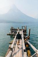 uomo che cammina sul molo nel parco nazionale del ghiacciaio foto