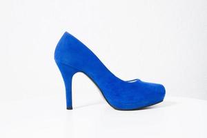 vicino su blu alto tacco donne scarpa isolato su bianca sfondo. moda donna Accessori. selettivo messa a fuoco. femmina scarpe su il pavimento. foto