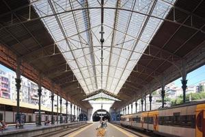 treno stazione, persone in attesa a il fermate, acciaio colonne e travi, ornamento su il colonne foto