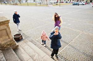 famiglia che cammina nella città di valtice, repubblica ceca. ragazzo fa una foto di monumenti culturali per telefono.