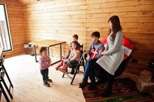 famiglia con bandiere danimarca all'interno della casa di legno. viaggiare nei paesi scandinavi. i danesi più felici. foto