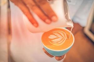 barista fabbricazione un' tazza di caffè latte macchiato arte. avvicinamento Visualizza di tazza di mattina bevanda. idilliaco contento positivo umore, prima colazione foto