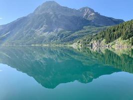 specchio d'acqua e montagna sotto il cielo blu foto