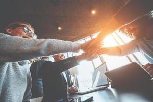 vicino su di giovane attività commerciale persone mettendo loro mani insieme. pila di mani. unità e lavoro di squadra concetto.. foto