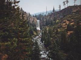 cascata tra alberi e colline foto