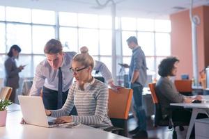 Due attività commerciale persone Lavorando con il computer portatile nel ufficio foto