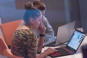 avviare donne d'affari Lavorando con il computer portatile nel creativo ufficio foto