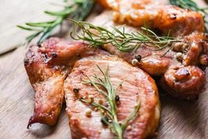 carne di maiale alla griglia con salsa ed erbe e spezie cucinando cibo tailandese asiatico maiale al rosmarino sul tagliere foto