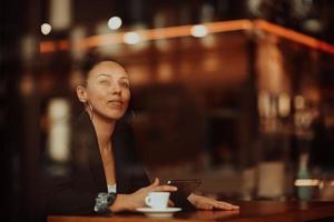 un' latino donna seduta nel un' bar su un' rompere a partire dal opera foto