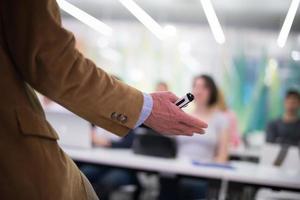 vicino su di insegnante mano mentre insegnamento nel aula foto